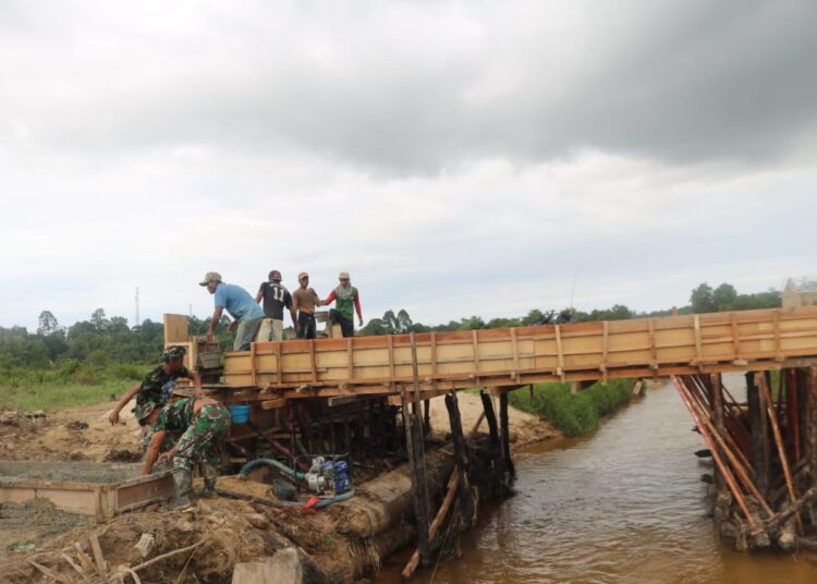 Bersama Warga Satgas TMMD Kompak Selesaikan Pengecoran Tiang Pondasi Jembatan.