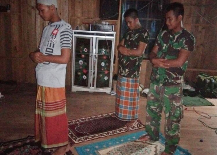 Personel Satgas TMMD Sholat Maghrib Berjamaah Bersama Warga